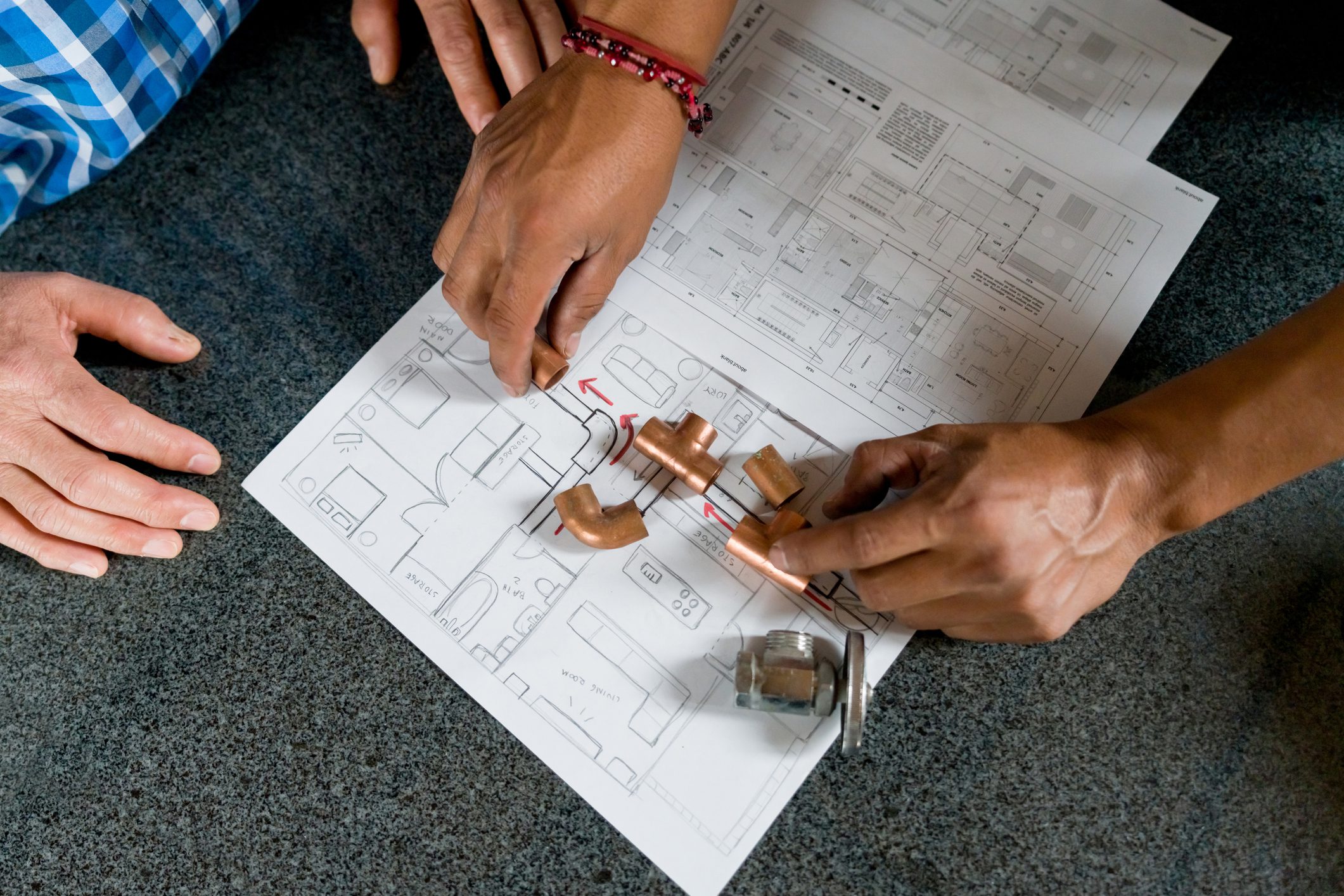 Hands working on electrical circuit diagram.