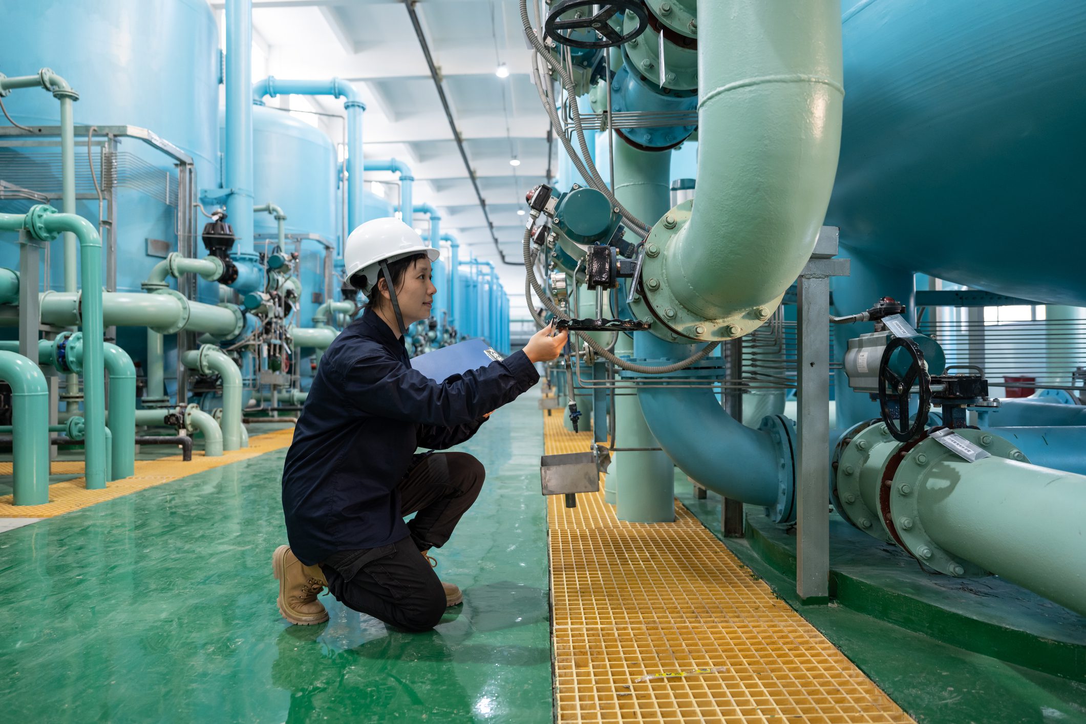 Engineer inspecting large industrial pipes system.