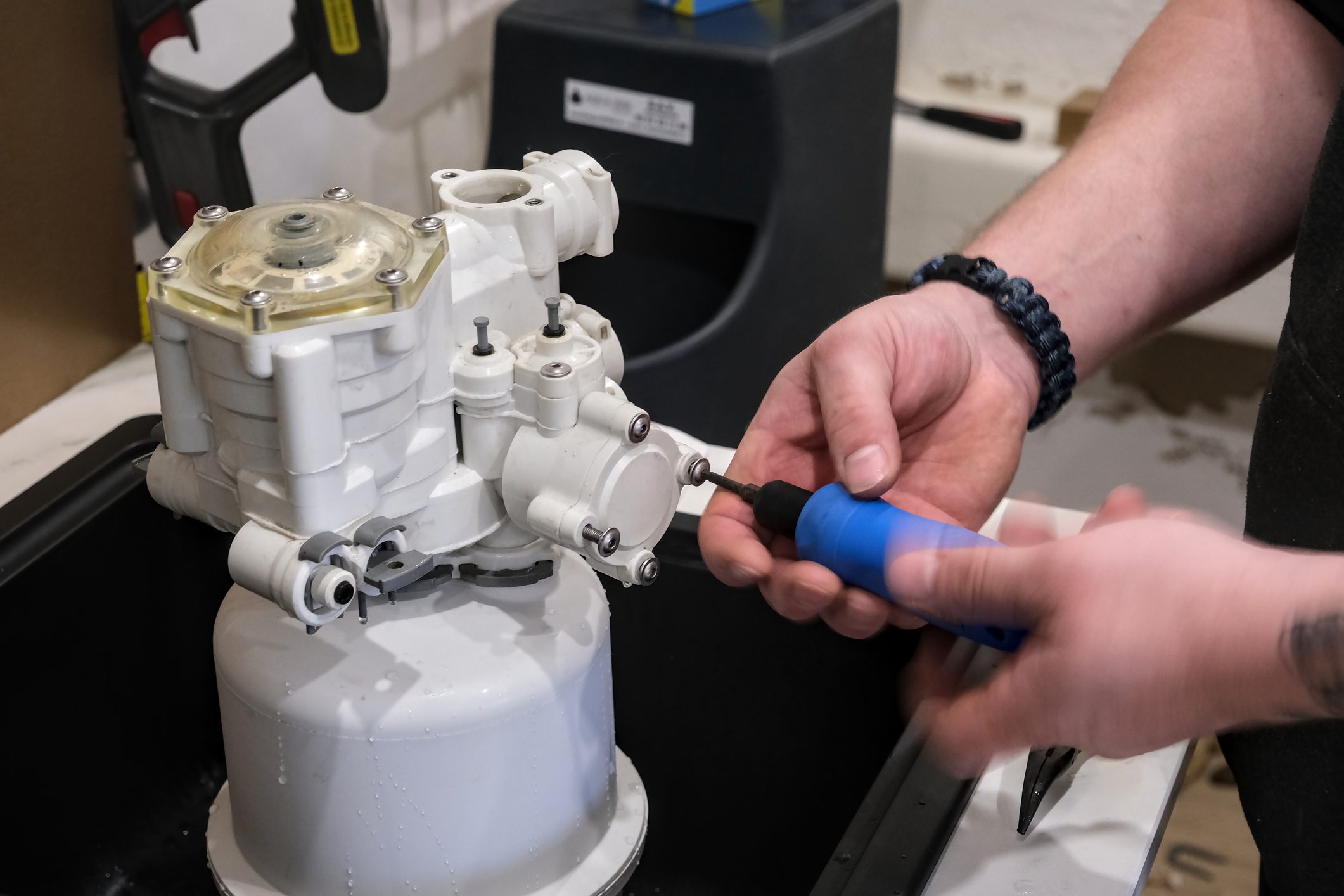 Man assembling a mechanical device with tool.