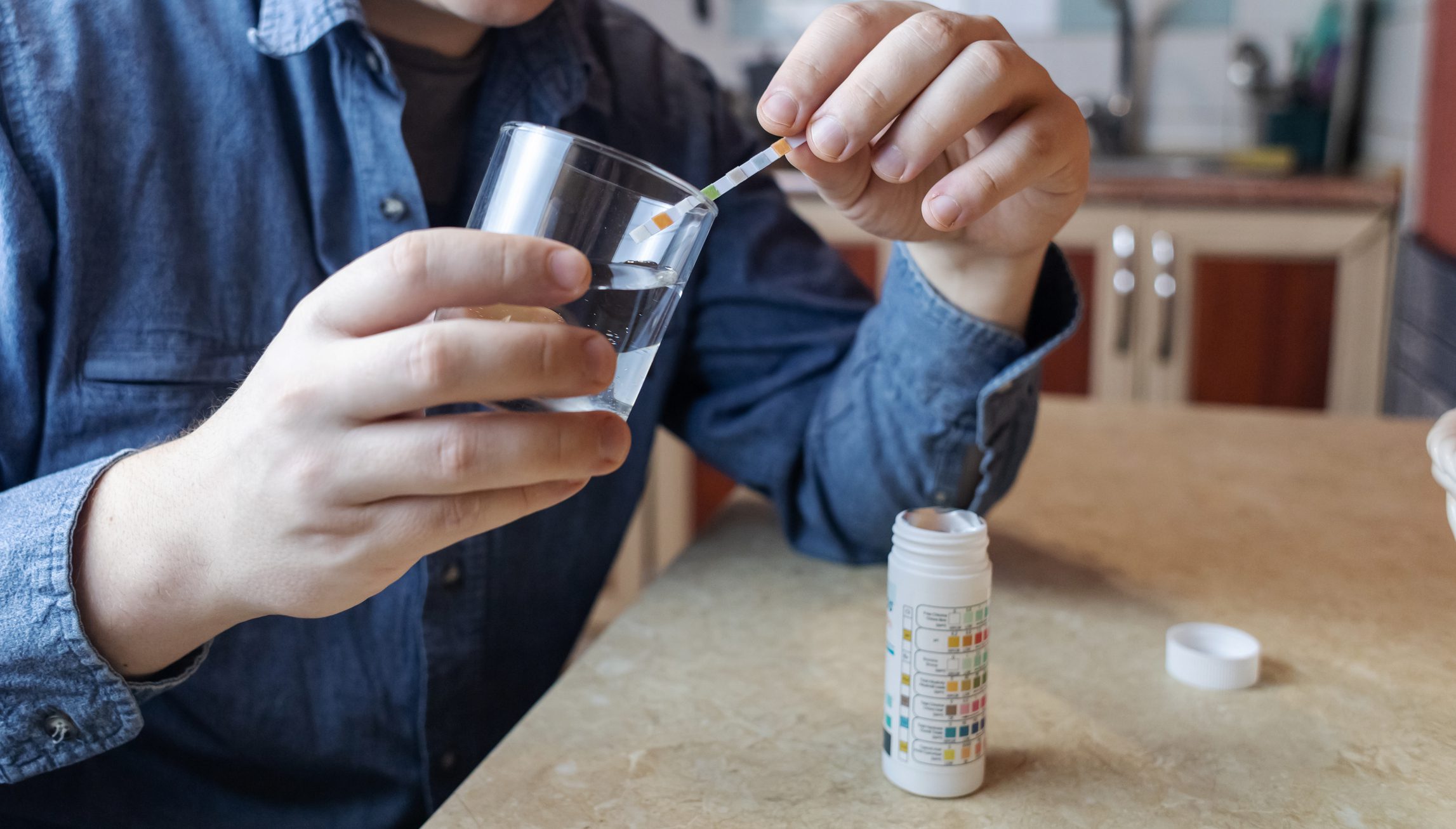 Person testing water with a pH strip.