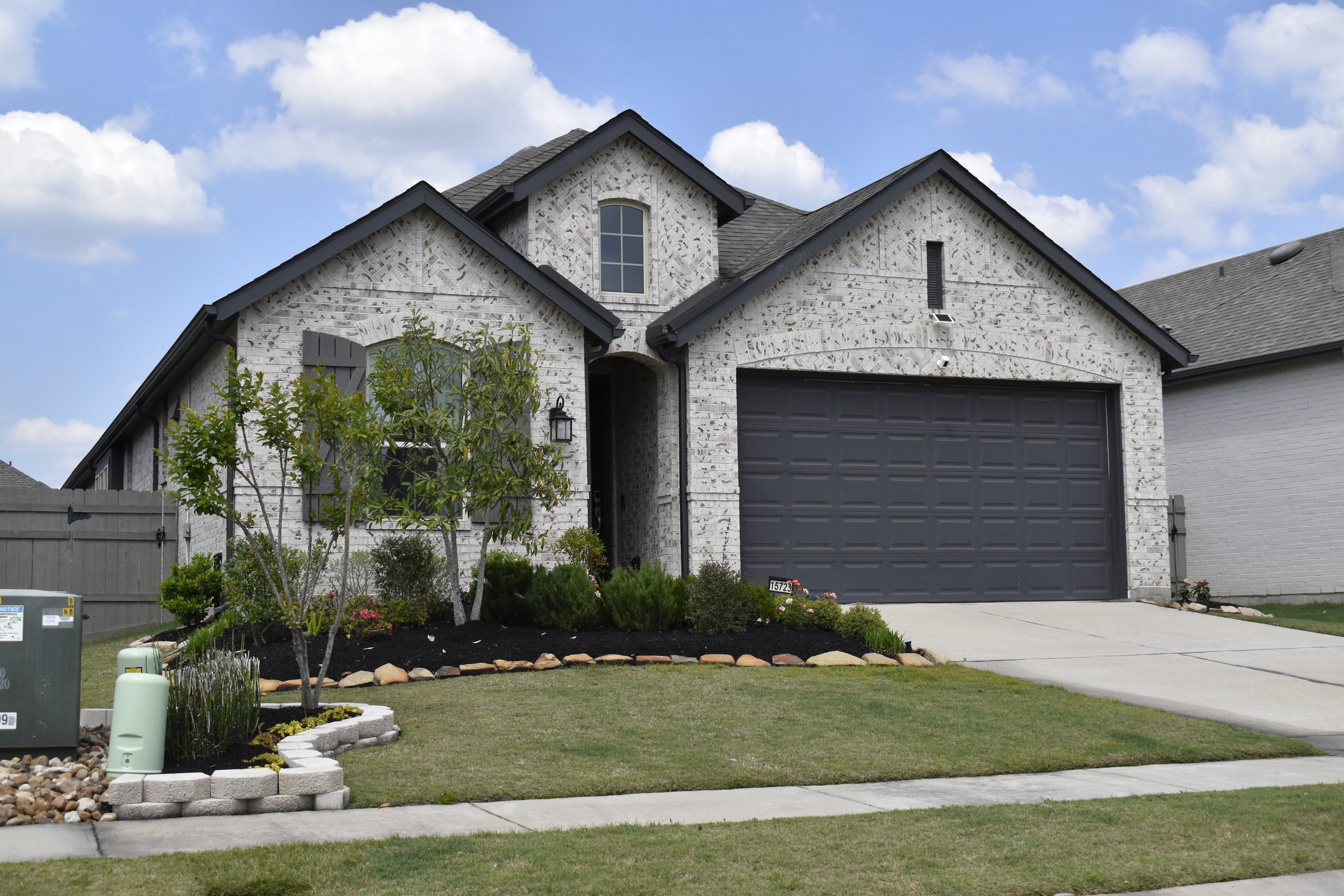 Suburban brick house with a landscaped yard.